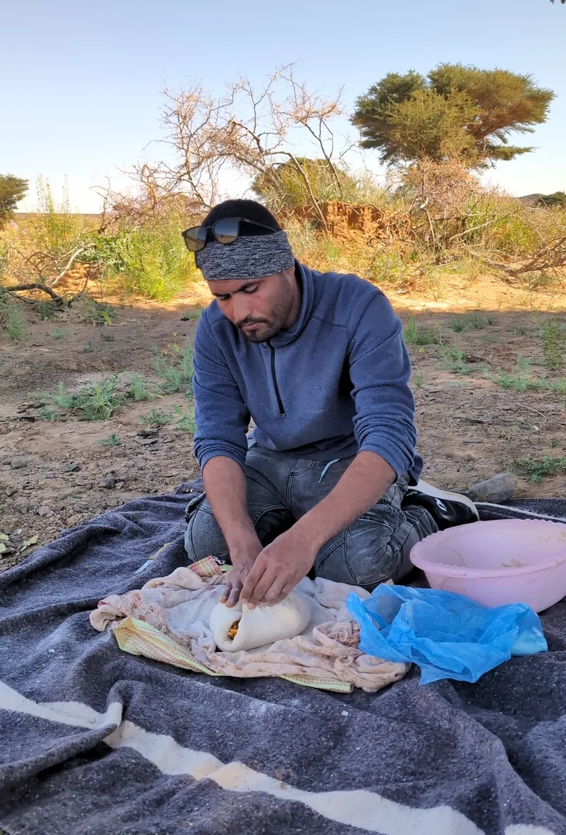 Mohamed preparing Madfouna during a Berber pizza cooking class in Merzouga